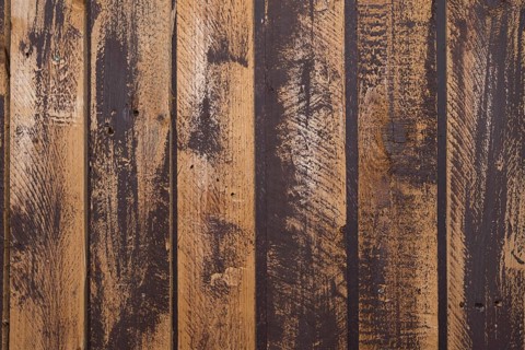 Unevenly painted dark wooden wall, uneven colour on the boards