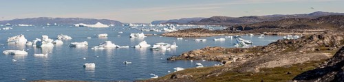 A breathtaking coastal landscape near Ilulissat, Greenland, featuring the Arctic Ocean dotted with