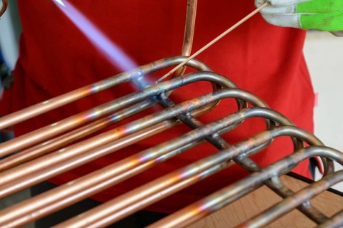 Skilled worker brazing copper - close-up