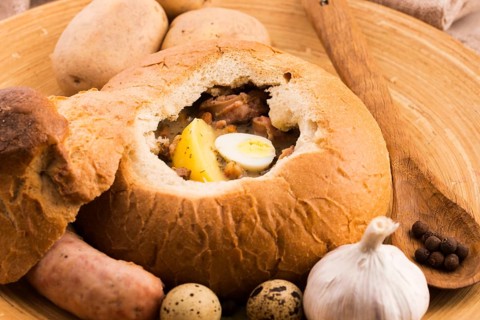 Traditional white borscht (zurek) with sausage, egg and mushrooms in bread as bowl