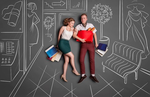 Love story concept of romantic couple shopping against chalk drawings background. Young happy
