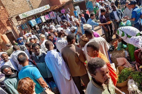 Large crowds at a lively market, surrounded by stalls and lively exchanges, The marketplace of