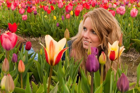 Portrait of a beautiful blond Dutch girl in tulips field