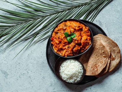 Indian cuisine dishes: tikka masala, rice, samosa, chapati, . Indian food on gray stone background