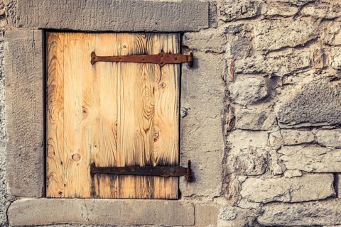 Rustic architecture background with a stone wall of a german house, with it's wooden trap door and