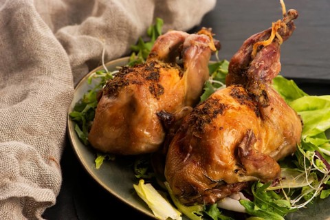 Baked tasty quails on ceramics plate with salad