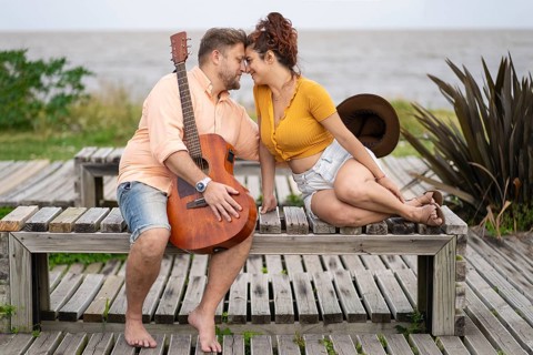Couple of musicians sitting on the beach about to kiss