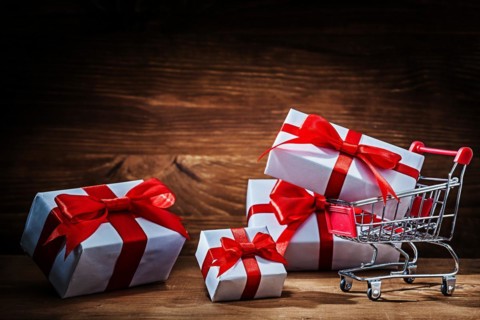 Set of white gift boxes with shopping trolley on vintage wood