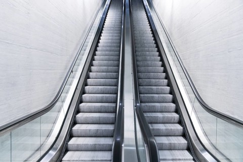 A horizontal view of an empty long escalator in a train station