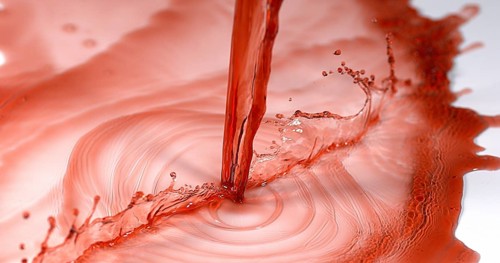 Red Wine being poured against White Background