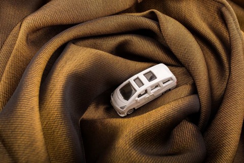Miniature metal car on a brown fabric cloth