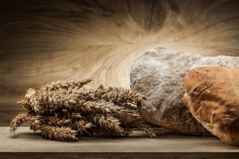 Loafs of bread and ears on vintage wood