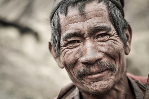 Dolpo, Nepal, circa May 2012: Old wrinkled man with grey hair and moustache smiles nicely to