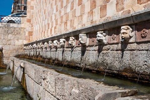 Famous mediaeval Fountain of 99 Spouts in ithe old town of L'Aquila, Abruzzi in Italy