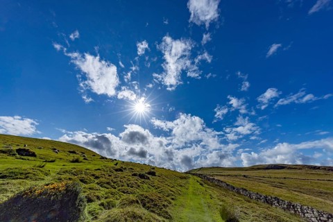 Hilly landscape with green meadows and stone wall, dry stone wall on the edge of Snowdonia National