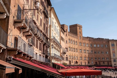 Old medieval brick houses surrounding the famous Piazza del Campo in the center of Siena, Italy,