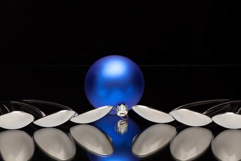 Blue Christmas decoration and six spoons on a black glass desk