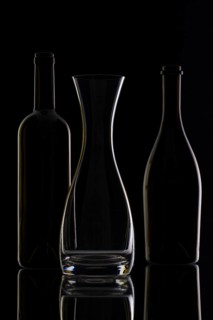 Empty glass and bottles on the black background