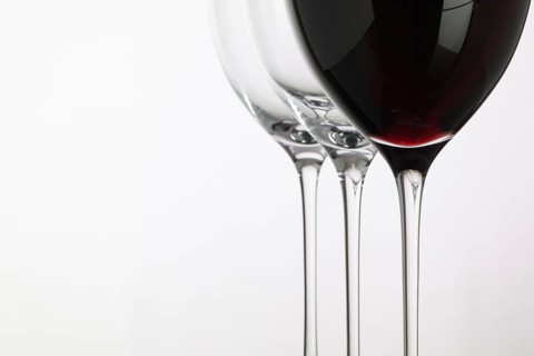 Wineglass with red wine on a white background