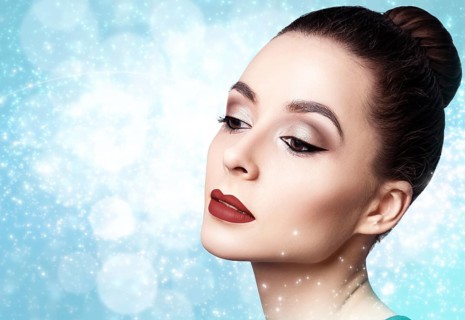 Portrait of young and beautiful woman with evening make-up over winter Christmas background