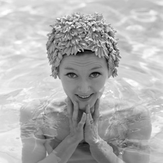 In the 1960s. A young woman pictured in the swimming pool wearing a typical 1960s bathing cap in a