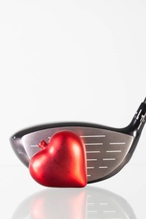 Golf club and red heart on a glass table