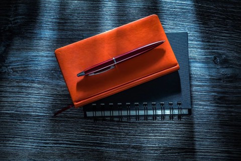 Notebooks pen on vintage wooden board
