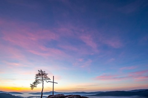 Summit cross on a sandstone rock in the middle of the forest. Landscape with a marvellous view over