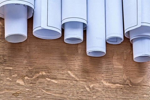 Pile of construction plans on wooden oaken board maintenance concept