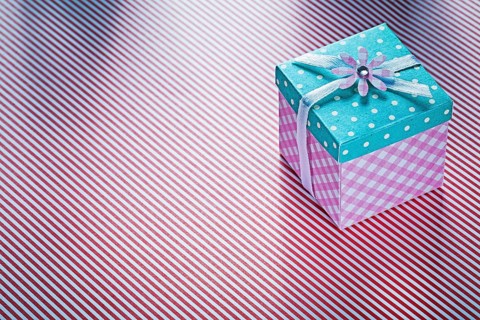 Present box on striped fabric background holidays concept