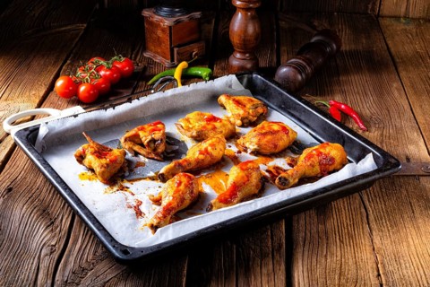 Rustic backed chicken wings, legs on baking tray
