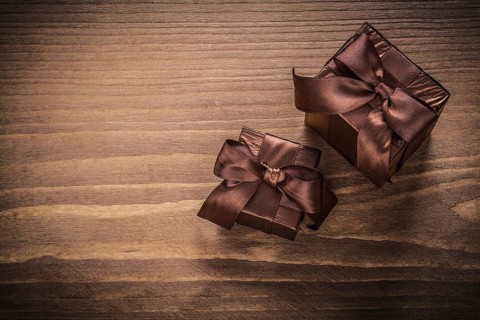 Packed glittery gift containers with ribbons on vintage wooden board