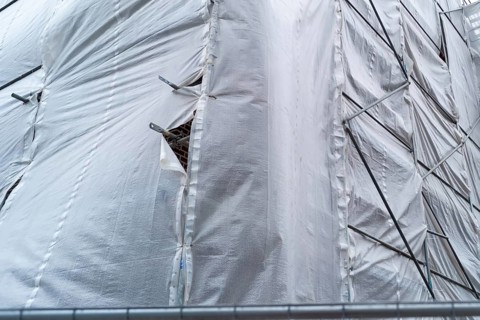 Building covered with a tarpaulin
