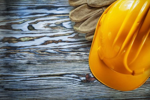 Safety gloves building helmet on vintage wooden board