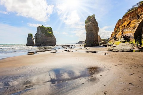 Low tide exposed the coastal strip of the ocean. Coastal cliffs. The Tongaporutu beach on the