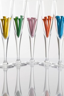 Glasses of champagne and golf equipments on a glass table
