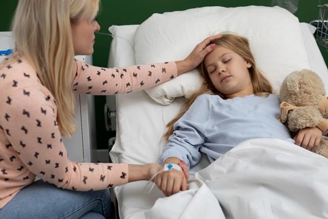 A mother comforts her sick daughter in a hospital bed, showing deep love and support during this