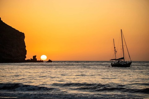 Sunrise during a storm, Calima. A haze-covered horizon turns orange as the sun rises as a ball. A