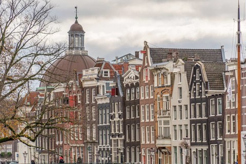 Typical Dutch house facades with gables and a church in the background, Amsterdam, Netherlands
