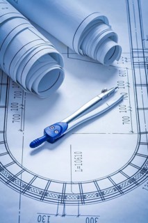 Blueprint rolls and pair of compasses construction concept
