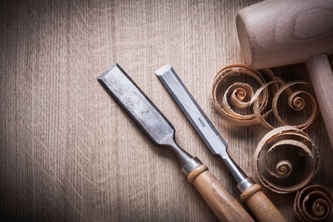 Planing chips wooden mallet carpenter??™s flat chisels on wood surface construction concept