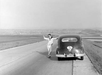 Vaction in Italy in the 1951. A man at his car during a car vacation trip in Italy. He has stopped