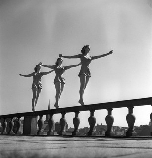 Gymnastics in the 1950s. Three young female gymnasts are standing on the wall outside Stockholm