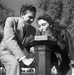 Summer in the 1940s. A girl drinks from a water fountain in one of Stockholms parks. These public