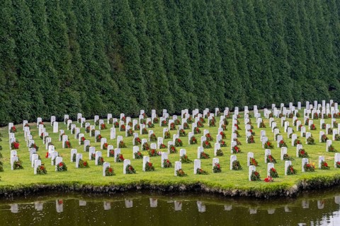 Atop a hill, a veterans cemetery with white headstones and the American flag evokes deep honour,