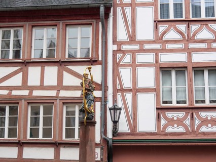 Half-timbered wall with statue of the Virgin Mary standing next to a street lamp post, mainz,