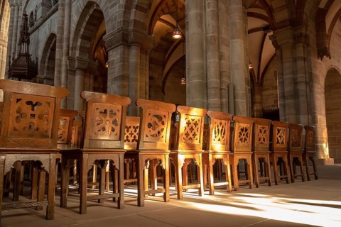 An image of a row of wooden chairs in an old church