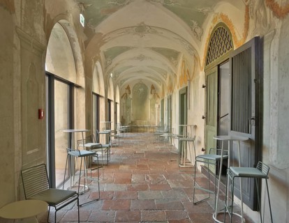Modern bistro seating in a historic arcade with fresco paintings, successful combination of