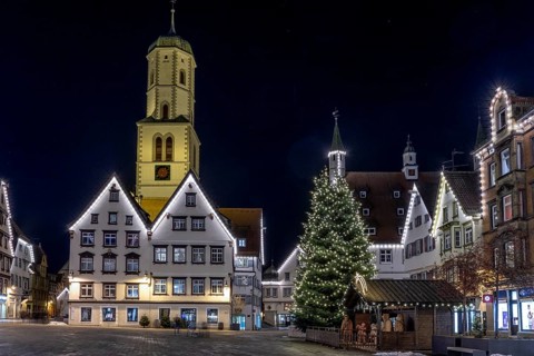 Night photo of historic buildings around the market square with Christmas tree and Christmas lights