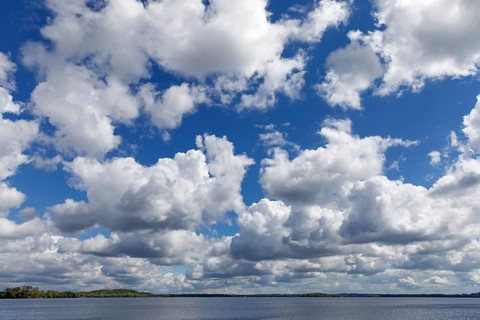 Blue sky with white to grey clouds over the Plöner See in Schleswig-Holstein. These are cumulus